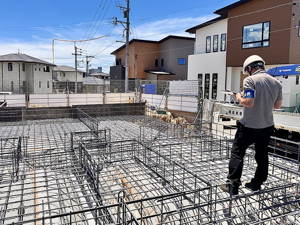基礎全体の配筋を確認する検査員