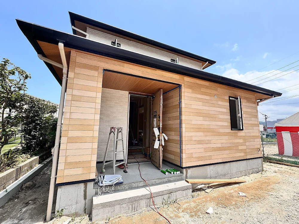 木目調の外壁と深い軒が印象的な玄関まわりの外観